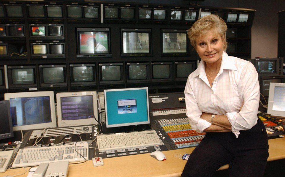 a woman sitting in front of a computer monitor that says windows on it