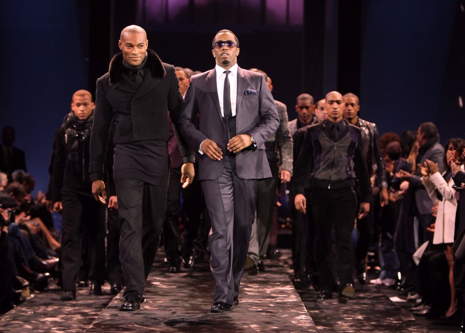 a group of men in suits are walking down a runway