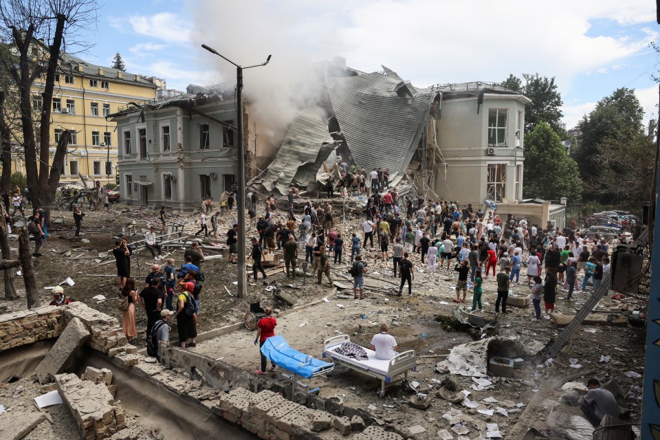 a large group of people are gathered around a collapsed building