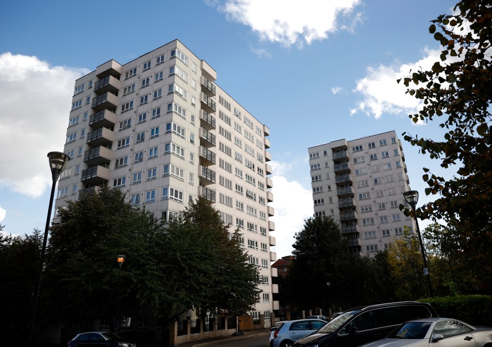 a tall building with cars parked in front of it