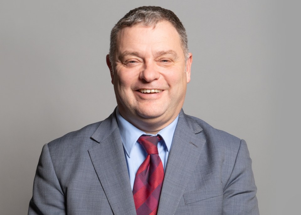 a man in a suit and tie smiles for the camera