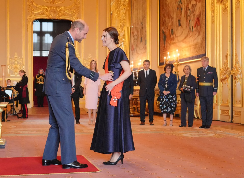 She shared a giggle with Prince William as he pinned the gleaming gong on to her red sash