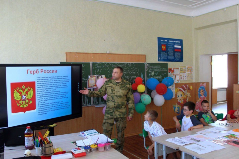 a man in a military uniform is giving a presentation in a classroom