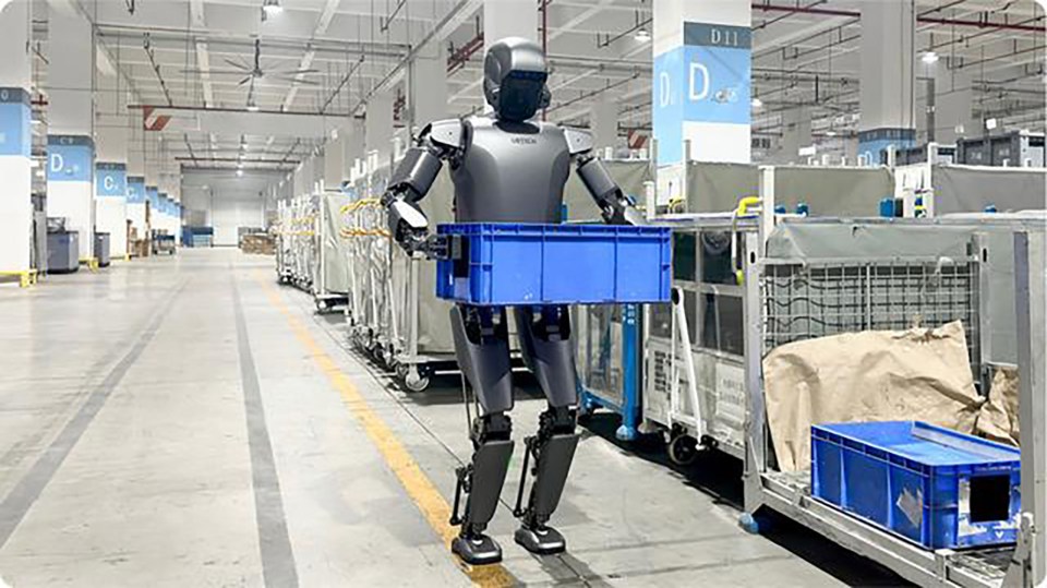 a robot is carrying a blue crate in a warehouse .