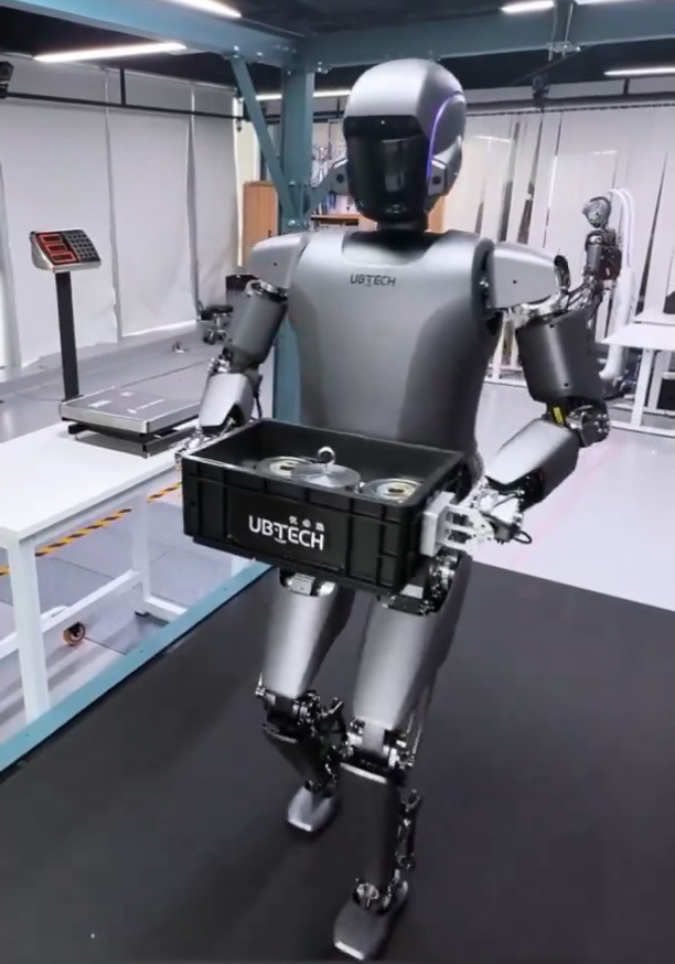 a robot is carrying a crate that says ubtech on it