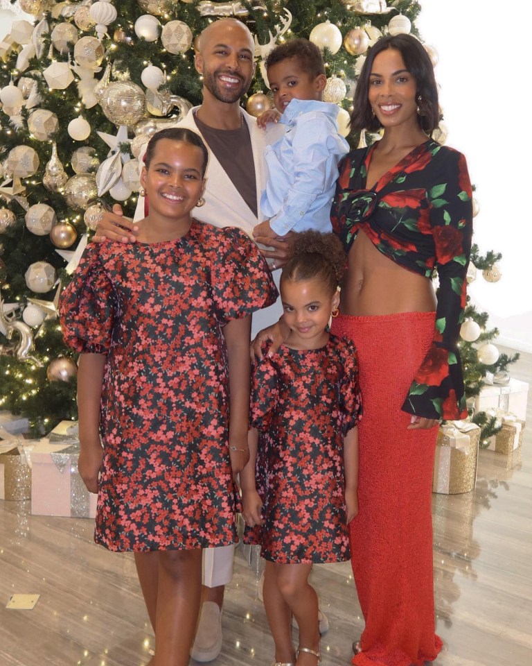 a family poses in front of a christmas tree