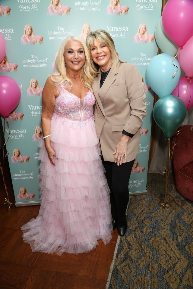 two women are posing for a picture in front of a wall that says vanessa born all