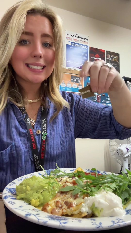 a woman wearing a lanyard that says " i love you " holds up a plate of food