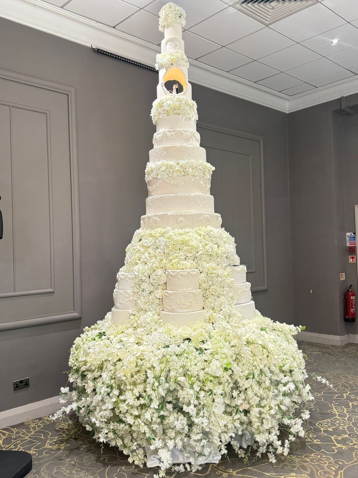 The show-stopping outfit was almost overshadowed by the wedding cake which was so tall it touched the ceiling