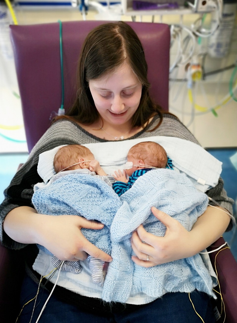 a woman is holding two babies in her arms