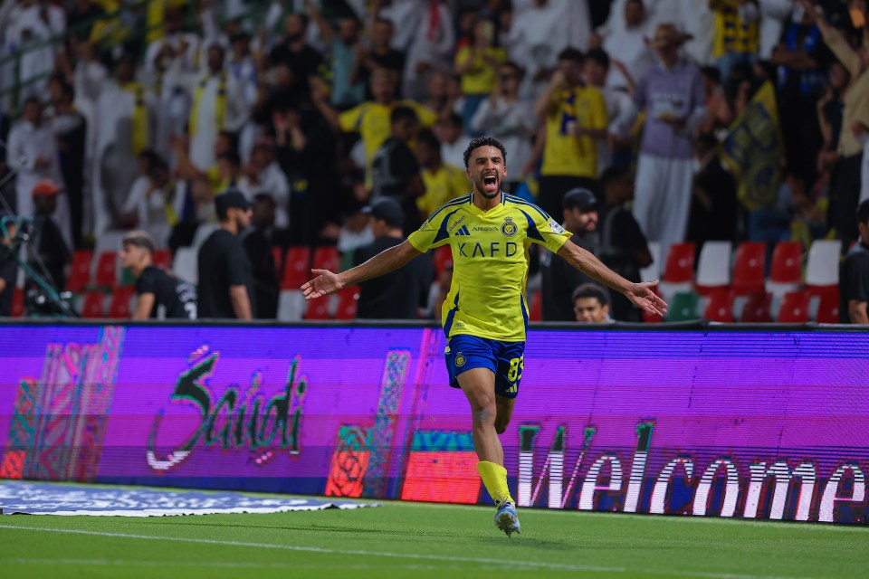 a soccer player wearing a kafd jersey celebrates a goal