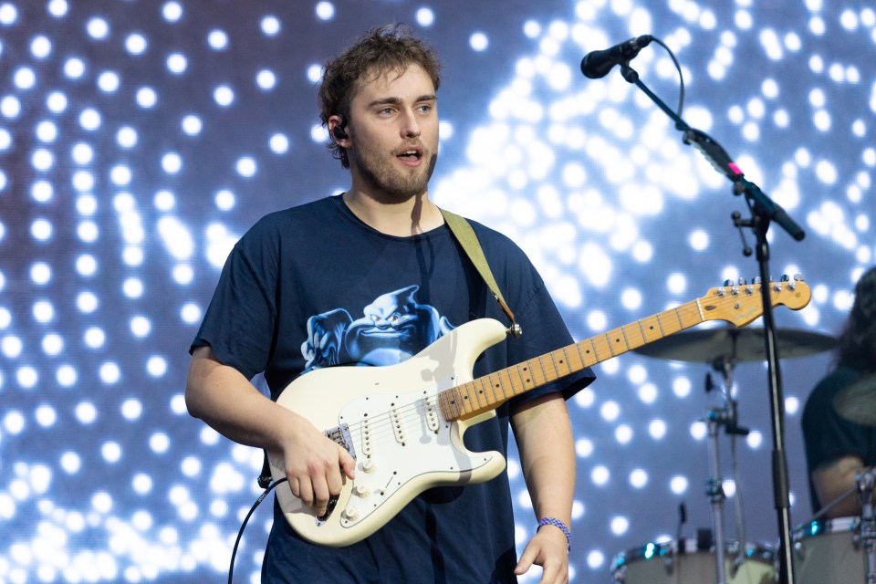 a man playing a guitar and singing into a microphone