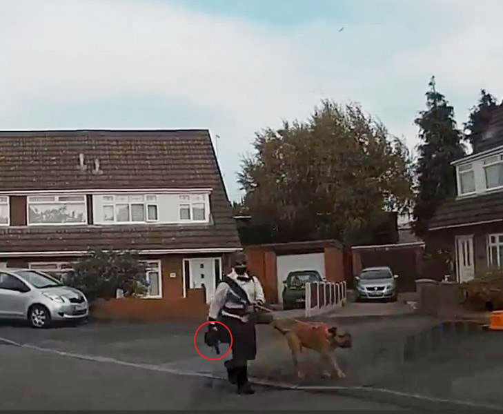 a man in a kilt is walking a dog on a leash