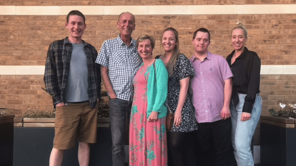 a group of people standing in front of a brick wall