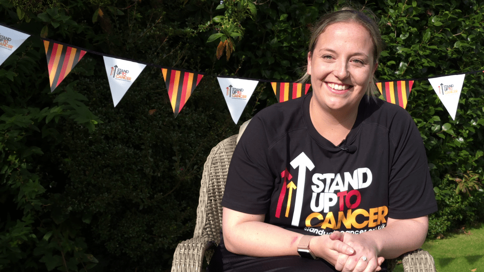 a woman wearing a shirt that says stand up to cancer