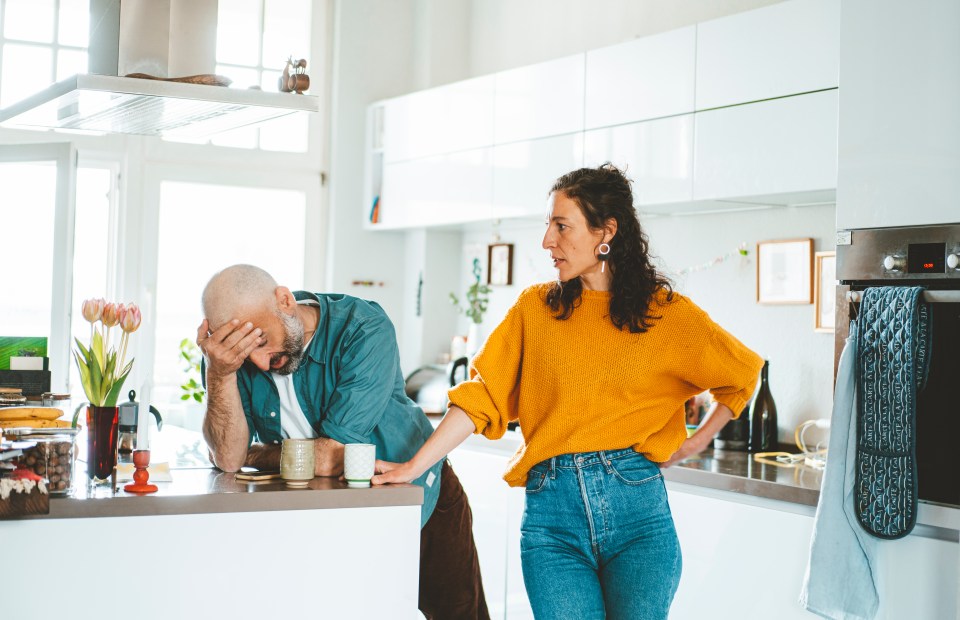 a woman in a yellow sweater stands next to a man in a blue shirt