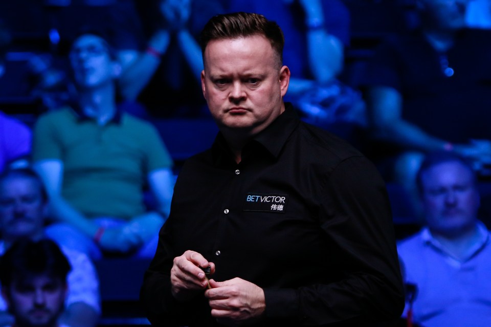 a man wearing a bet victor shirt stands in front of a crowd