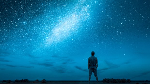 a man stands in front of a starry night sky