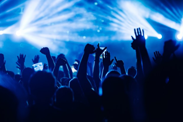 a crowd at a concert with their hands in the air