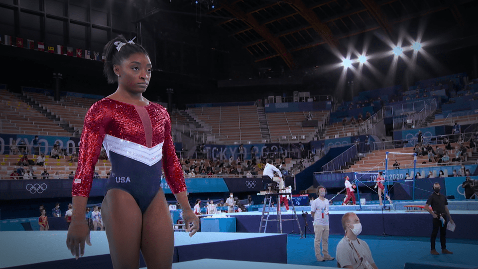 a gymnast wearing a red white and blue leotard that says usa