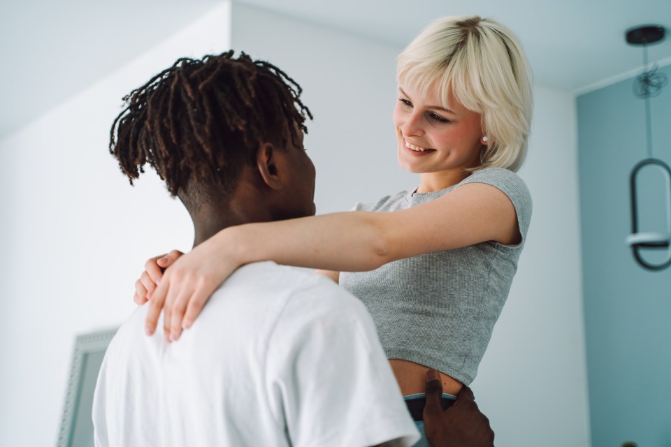 a man is holding a woman in his arms who is smiling