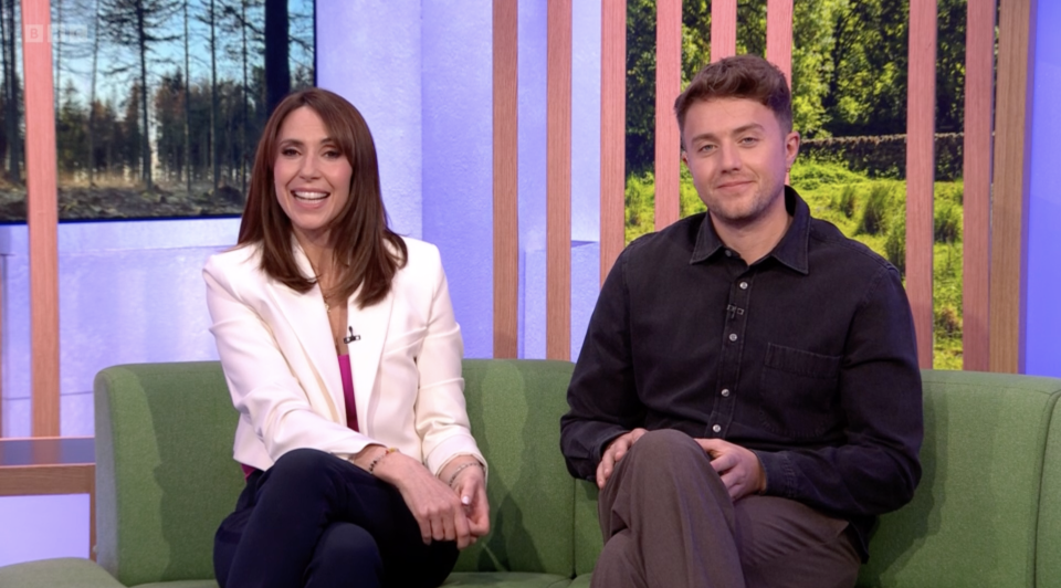 a man and a woman are sitting on a green couch