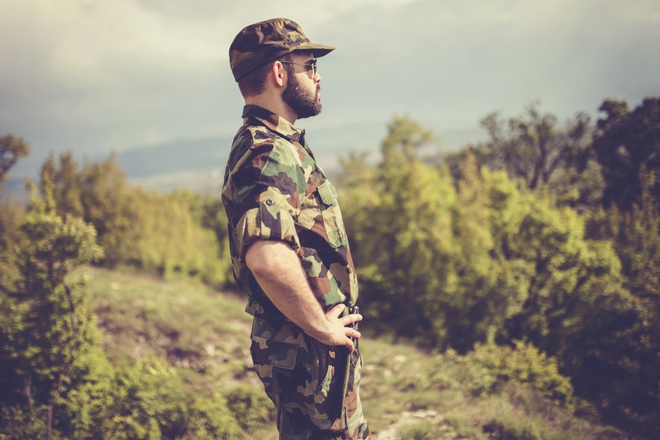 a man in a military uniform stands with his hands on his hips