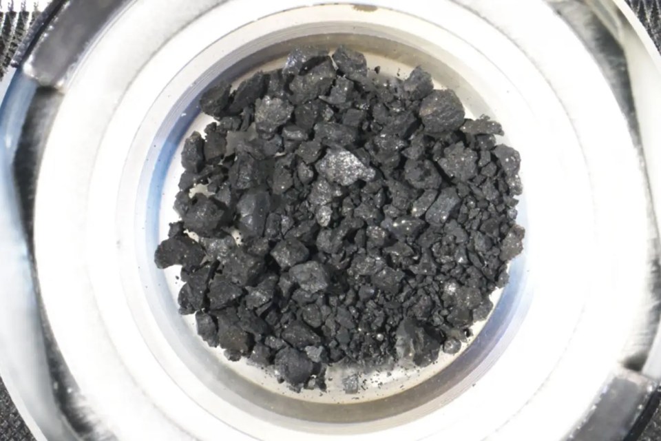 a pile of black rocks in a metal container