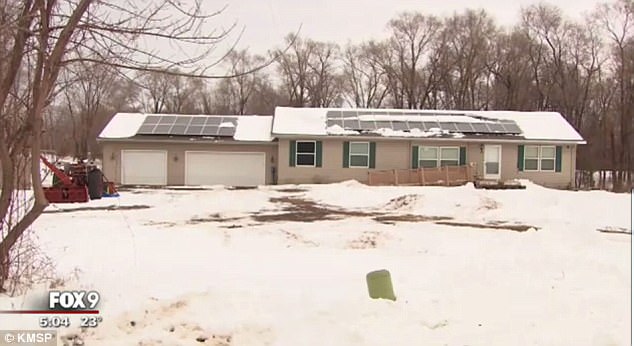 a house with solar panels on the roof is covered in snow .