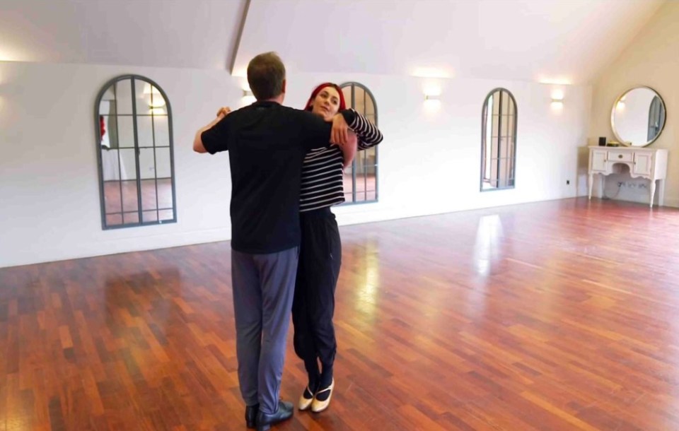 a man and a woman are dancing in an empty room