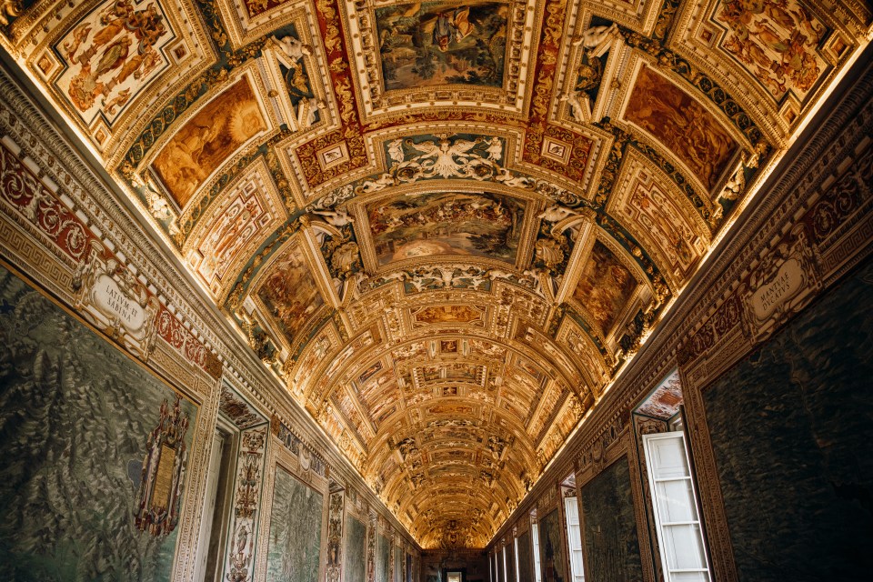 a long hallway with a ceiling that has a painting on it