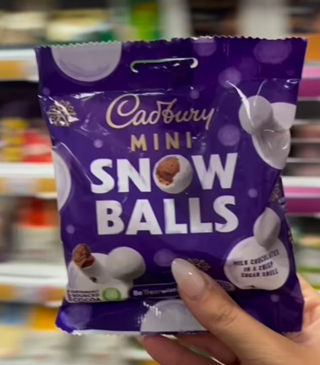 a person is holding a bag of cadbury mini snow balls