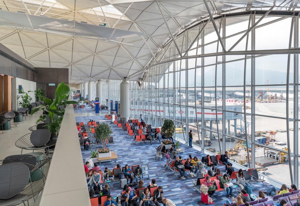 people are sitting in a waiting area at an airport