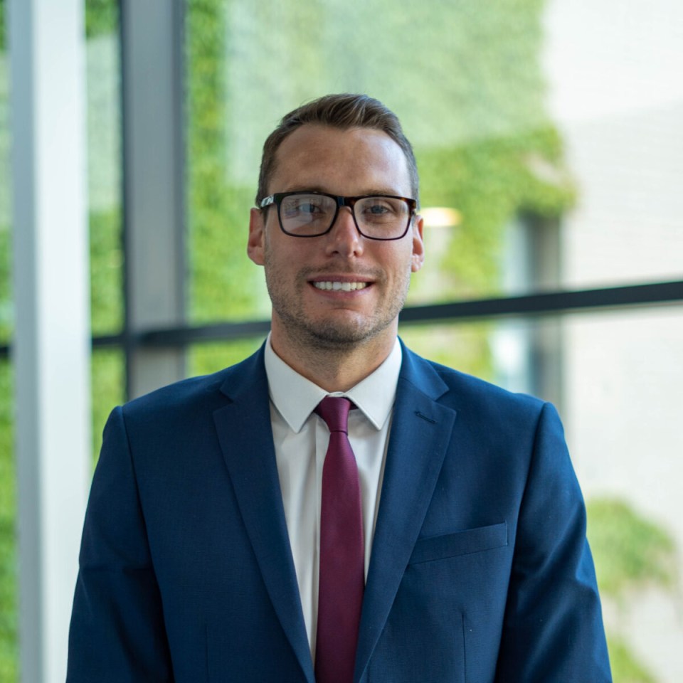 a man in a suit and tie smiles for the camera