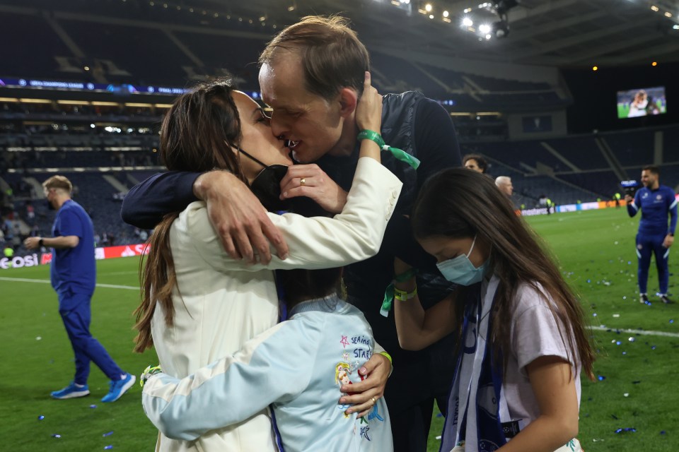 a man kisses a woman on the cheek while a girl wearing a shirt that says ' champions league '