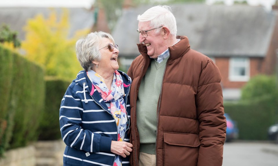 a man and woman are laughing and looking at each other