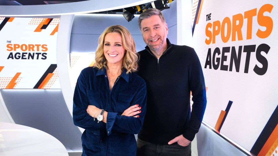 a man and a woman stand in front of a sign that says the sports agents