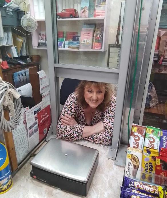 a woman behind a counter with a sign that says how are you