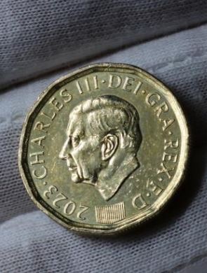 a close up of a gold coin with a man 's face on it .