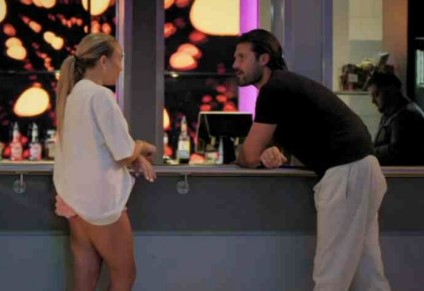 a man and a woman are standing next to each other in front of a counter .