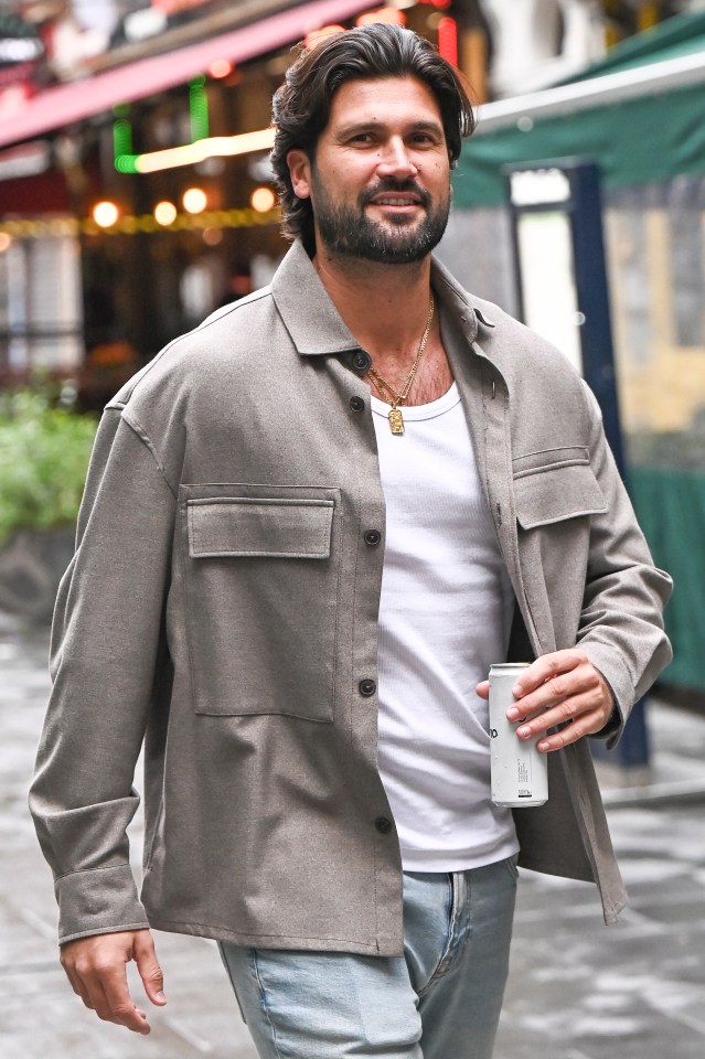 a man with a beard is holding a can of soda