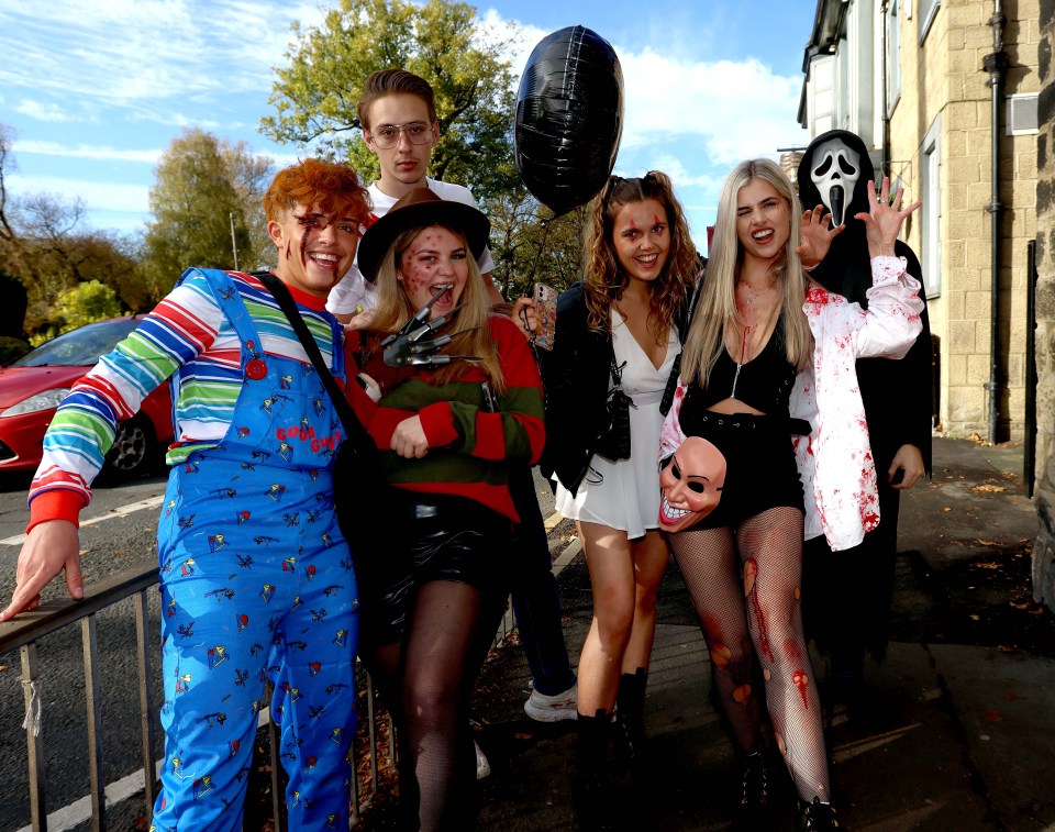 a group of people dressed in halloween costumes pose for a picture