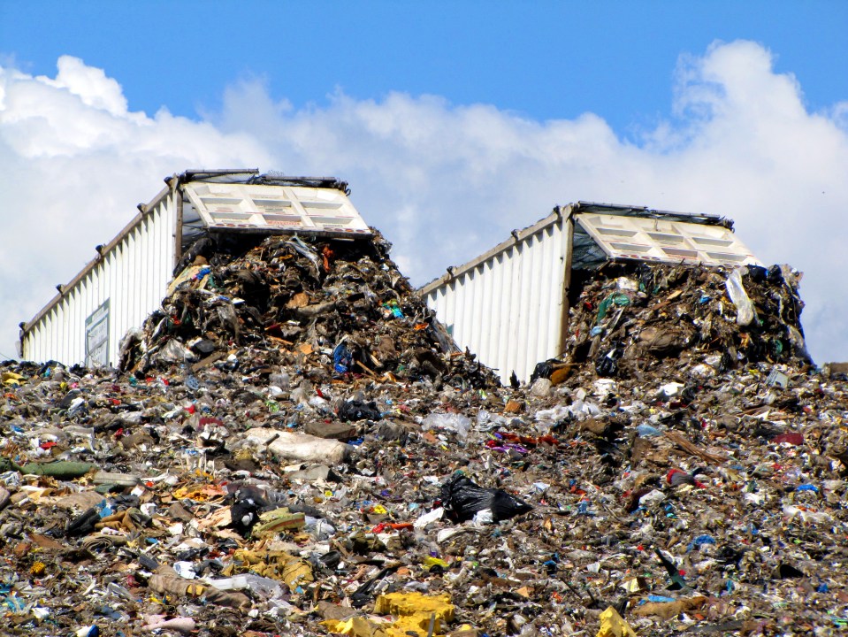 a large pile of garbage with two containers sitting on top of it