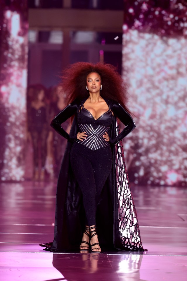 a woman with red hair is walking down a runway