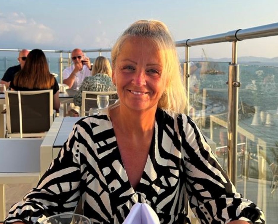 a woman in a black and white zebra print shirt sits at a table