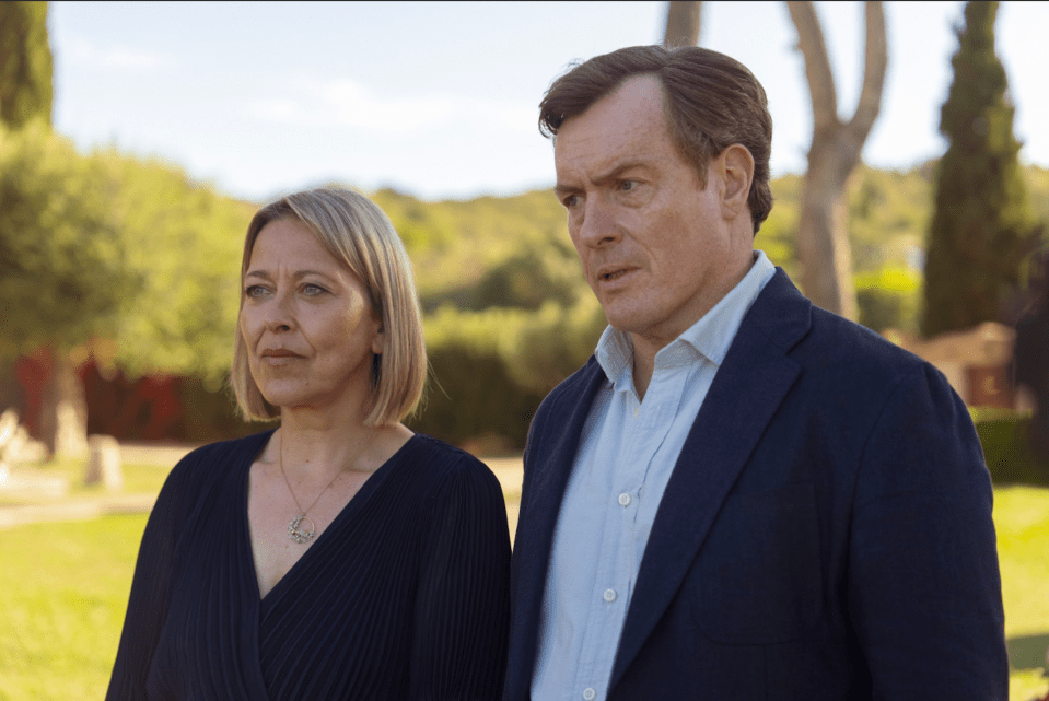 a man and a woman are standing next to each other in a park