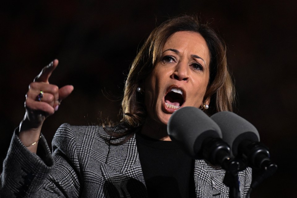 a woman speaking into a microphone with her mouth open