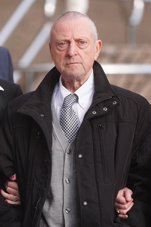 an older man wearing a black jacket and tie