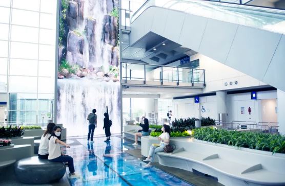 a group of people are sitting in front of a waterfall in a building .