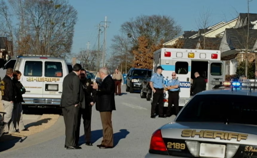 The house was surrounded by ambulances, police cars and a police helicopter on the day the killing was discovered